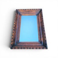 Vintage mirror features a cool combination of a leather covered frame and studs