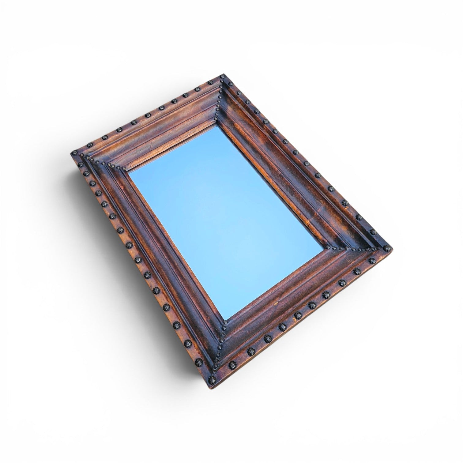 Vintage mirror features a cool combination of a leather covered frame and studs