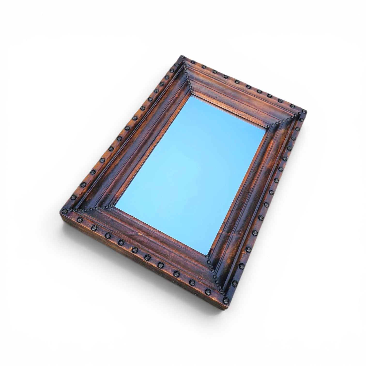 Vintage mirror features a cool combination of a leather covered frame and studs