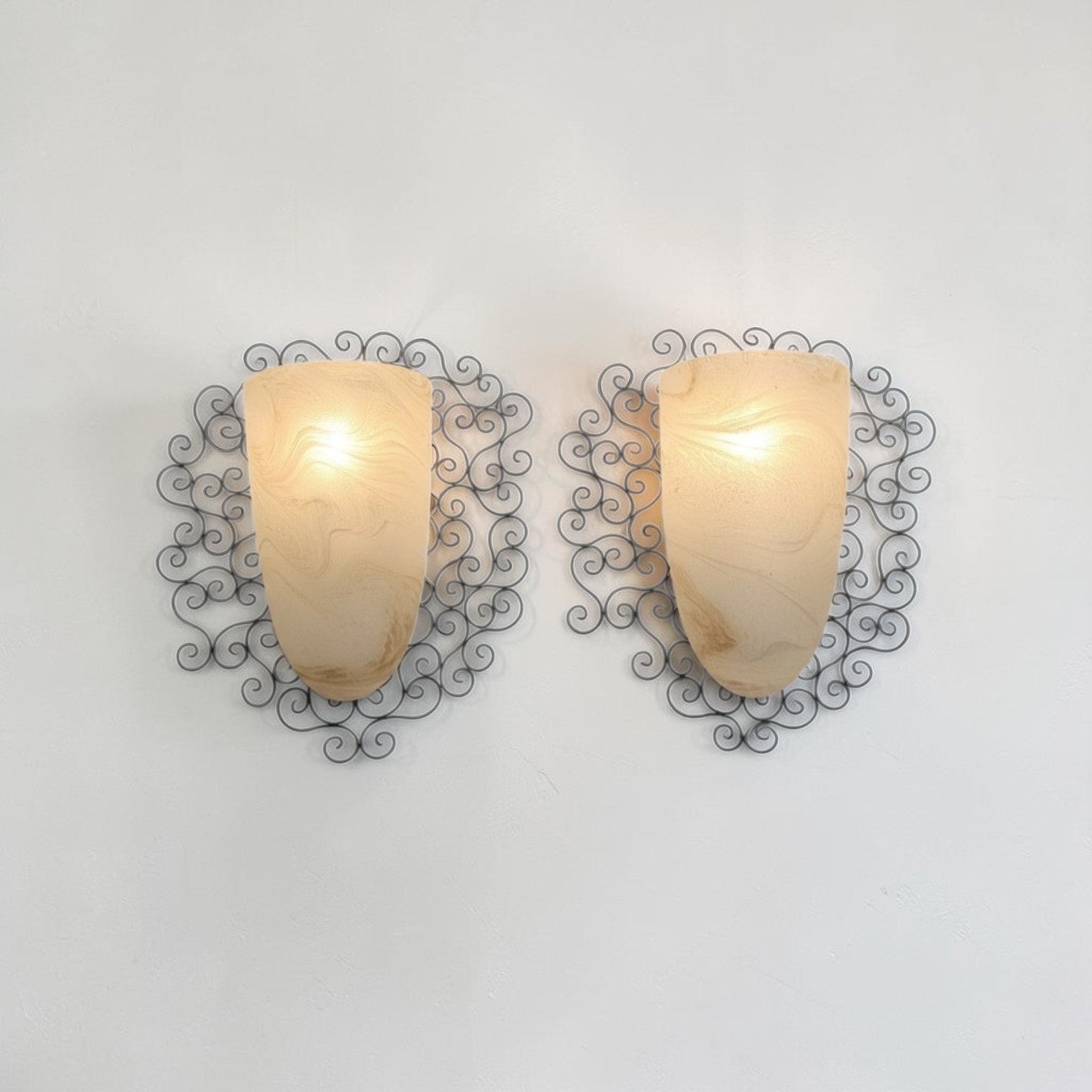 Wrought iron pocket wall sconces featuring a frosted amber glass / metal frame