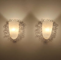 Wrought iron pocket wall sconces featuring a frosted amber glass / metal frame